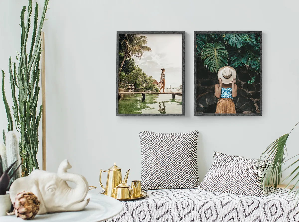 zwei Fotoposter mit Urlaubsbildern hängen an der Wand über einem Bett